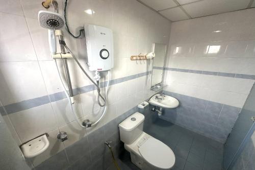 a bathroom with a shower and a toilet and a sink at ANGSA Hotel in Seremban