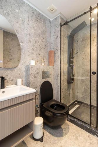 a bathroom with a black toilet sitting next to a shower at Appartement Anfa Park casa finance City CFC in Casablanca