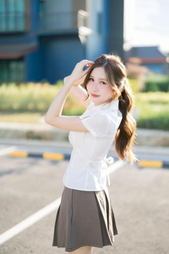 a woman wearing a white shirt and a skirt at The Horizon Groove Hotel in Ban Khlong