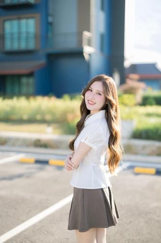 a woman wearing a white shirt and a skirt at The Horizon Groove Hotel in Ban Khlong