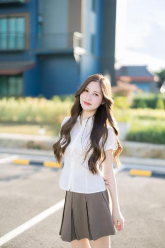 a young woman wearing a white shirt and a skirt at The Horizon Groove Hotel in Ban Khlong