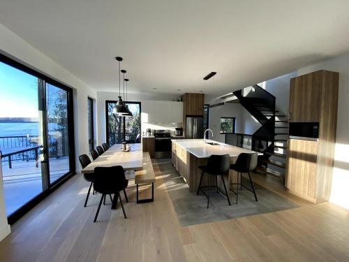 a kitchen with a table and chairs and a large window at Lakefront-Spa-Luxury in true nature! in La Minerve