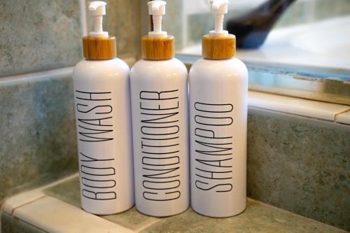 three white bottles sitting on top of a sink at New! Fair Winds Private Island Oases w Heated Pool & more! in Merritt Island
