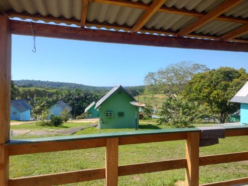 a view from a window of a green house at Chalé 01 Acqua Park - 06 km de Presidente Figueiredo-AM in Presidente Figueiredo