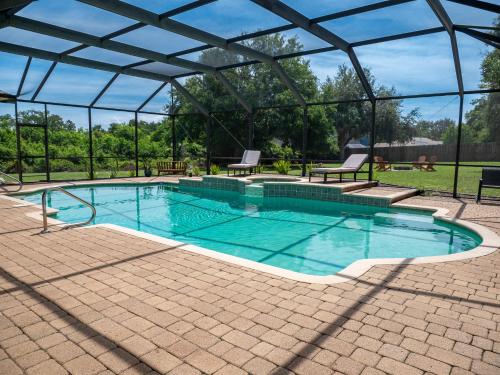a swimming pool with a pergola next to a patio at New! Fair Winds Private Island Oases w Heated Pool & more! in Merritt Island