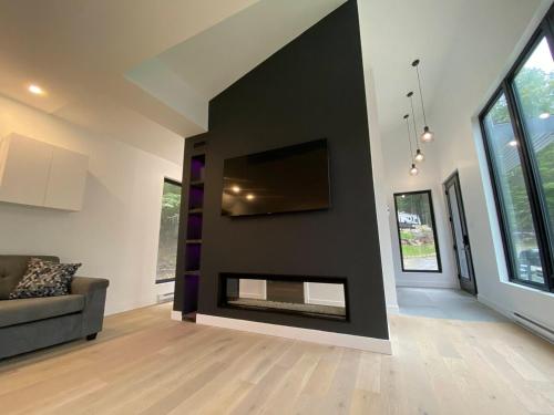 a living room with a black wall with a fireplace at Lakefront-Spa-Luxury in true nature! in La Minerve
