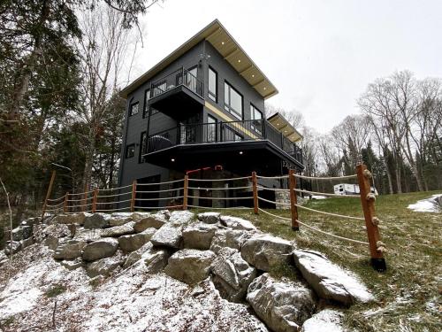 a black house on a hill with a fence at Lakefront-Spa-Luxury in true nature! in La Minerve