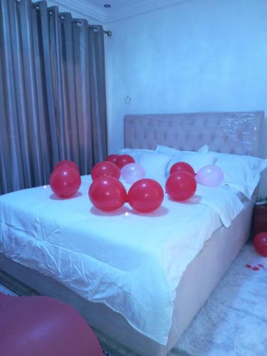a group of red and white balloons on a bed at Residence Julie in Douala