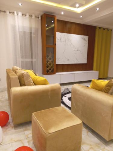 a living room with two couches and a television at Residence Julie in Douala