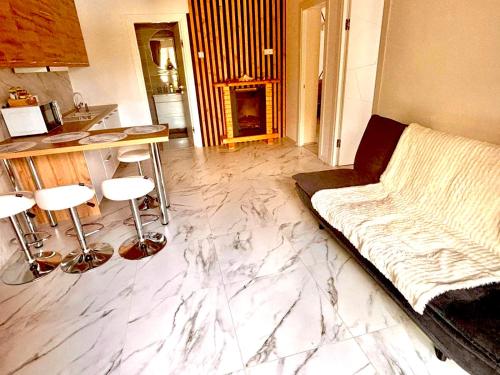 a living room with a couch and a marble floor at Подих Карпат in Slavske
