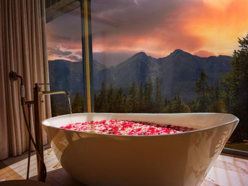 ジュディアルにあるLuxury Chalet Strachan - Jacuzzi and Saunaの窓の前にあるピンクの花で満たされた浴槽