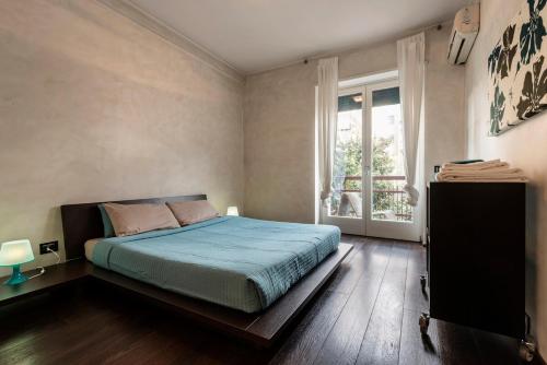 una camera da letto con un letto e una finestra di Quite and Bright Tortona District a Milano