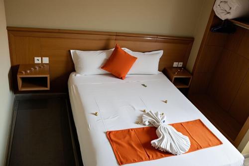 a bed with an orange towel on it at Hotel Golden Flora in Beni Mellal