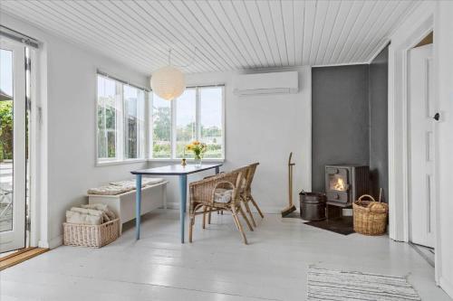 a dining room with a table and chairs and a fireplace at 30001-Malling-Hasselvaenget-7 in Malling