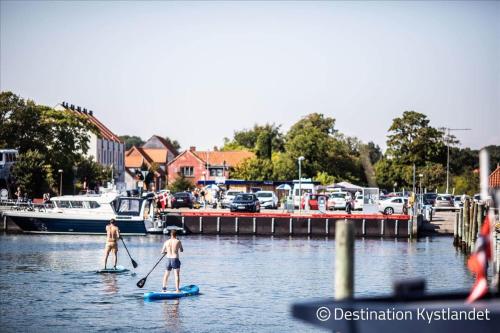 two men on paddle boards in the water near a marina at 30001-Malling-Hasselvaenget-7 in Malling