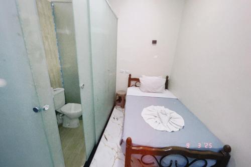 a small bathroom with a bed and a toilet at One Season Hotel in Cairo