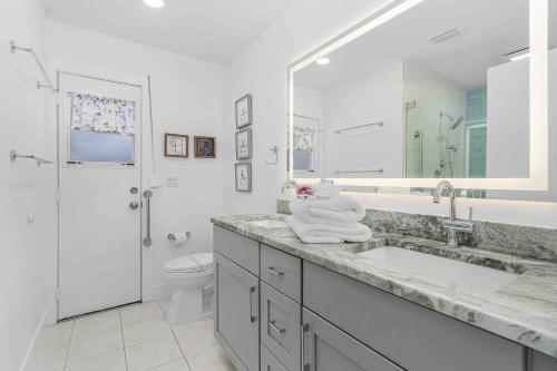 ein weißes Badezimmer mit Waschbecken und Toilette in der Unterkunft Surfside Breeze in Cape Coral