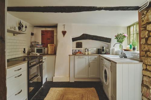 a kitchen with a sink and a dishwasher at Coniston House - Eco Hot Tub in Stow on the Wold
