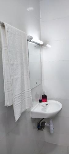 a white bathroom with a sink and a mirror at Boho Comfort Homes in Diani Beach