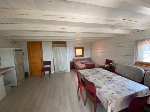 a living room with a table and a bedroom at Senelio Romo Sodyba in Molėtai