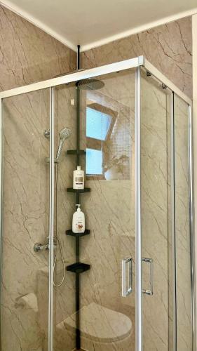 a shower with a glass door with a phone on it at Cobalto 2 Quartos Parque Cidade Pet Friendly in Aveiro
