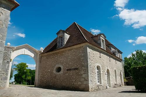 an old brick building with an archway on a blue sky at Château de Montramé in Soisy-Bouy