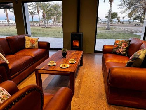 a living room with couches and a table and a fireplace at Flying Ostrich Guesthouse & Self-catering Accommodation in Mariental