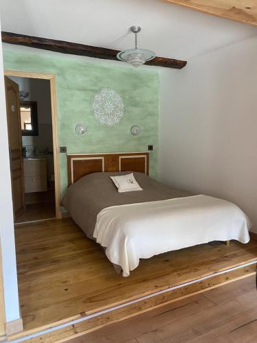 a bedroom with a bed with a green wall at Chez Philomène in Saint-Martin-Vésubie