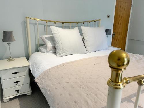 a bedroom with a bed with white pillows at Peak District Period Property near Chatsworth House in Bakewell