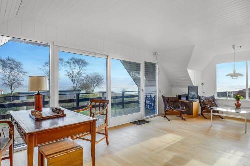 a living room with a table and some windows at 30582-Odder-Dyngby-Havvej-66 in Odder