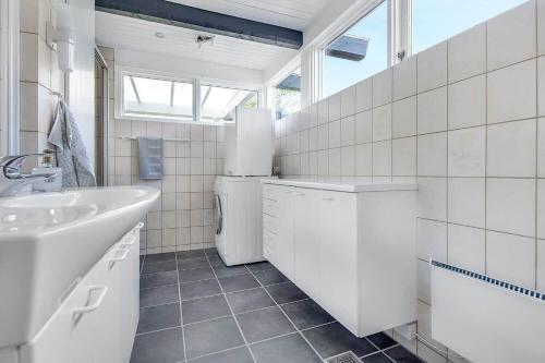 a white bathroom with a sink and a washing machine at 30582-Odder-Dyngby-Havvej-66 in Odder