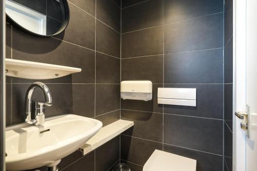 a bathroom with a sink and a toilet at Hotel-Pension Ouddorp in Ouddorp