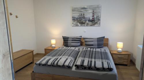 a bedroom with a bed with two lamps on it at Ankerplatz35 in Carolinensiel