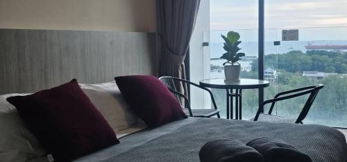 a bedroom with a bed and a table and a window at PD D'Wharf The Bay Superior Queen Room SeaView Balcony in Port Dickson