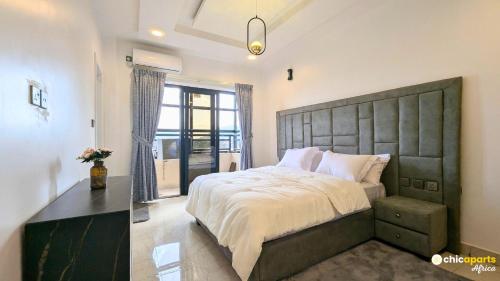 a bedroom with a large bed with a large headboard at Chic studio with parking and rooftop in Yaoundé