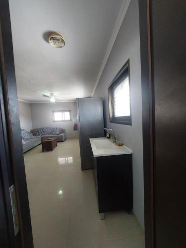 a bathroom with a sink and a living room at Centre studio 16 in Netanya