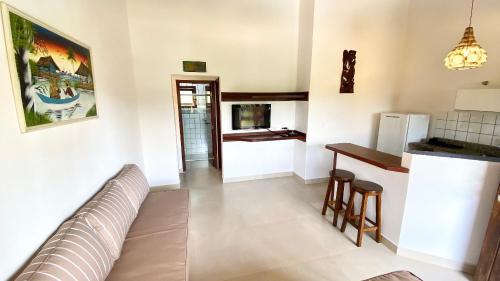 a living room with a couch and a kitchen at Residencial Villa Cris - Jd. São Lourenço/Itaguaré in Bertioga