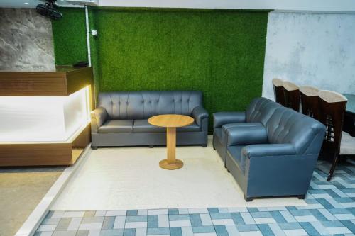 a waiting room with a couch and a table at Hotel Sunrise Deluxe in Pune