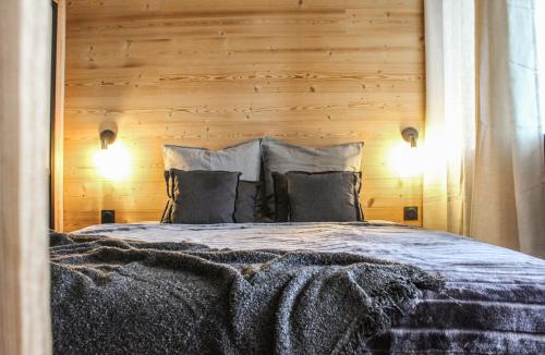 a bedroom with a large bed with a wooden wall at Le lodge étoilé - Station de ski Font-Romeu Pyrénées 2000 in Égat