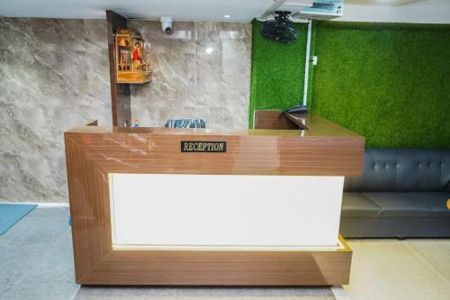 a reception desk with a sign on top of it at Hotel Sunrise Deluxe in Pune