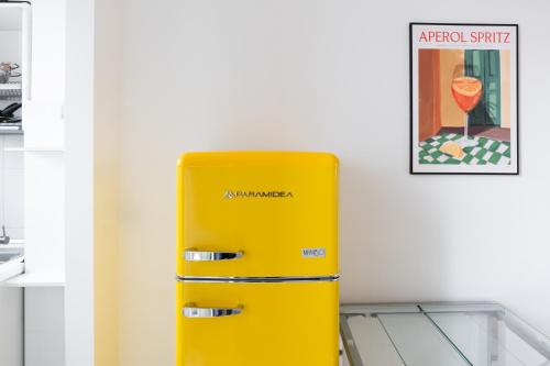 a yellow refrigerator in the corner of a room at Vivace Bilocale con vista sul Naviglio -Mirable PM in Milan