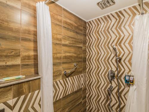 a bathroom with a shower with wooden walls at Munal and Mayur Resort - Wellness Retreat Pvt Ltd in Tikoli