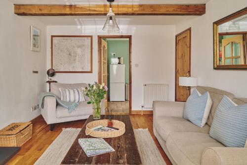 una sala de estar con un sofá y una mesa en Oakey Cottage - Complimentary Breakfast, en Bourton on the Water
