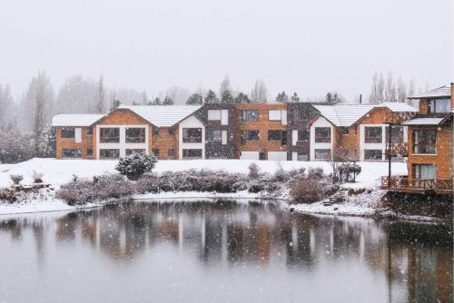 a snow covered city with a pond and houses at Blue Aparts Dina Huapi Bariloche in Dina Huapi