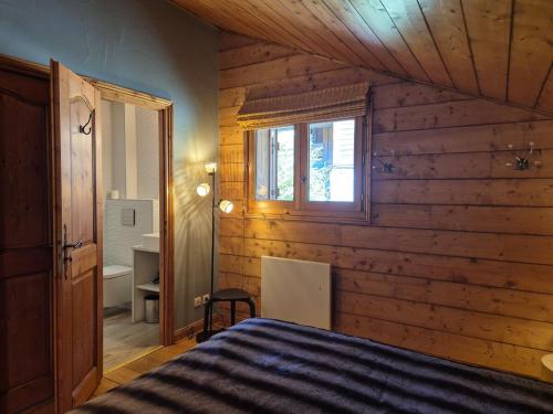 サント・フォア・タロンテーズにあるSplendide chalet 10pers, Sainte Foy Stationの木製の壁のベッドルーム1室、窓付きのベッド1台が備わります。