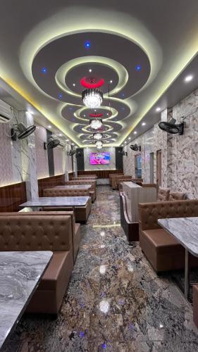 a restaurant with couches and a chandelier at The Little Heaven Hotel near Kolkata Airport in kolkata