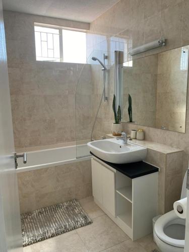 a bathroom with a sink and a shower and a toilet at 270 Degree City View Serenity in Windhoek