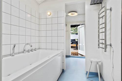 ein weißes Badezimmer mit Badewanne und Hocker in der Unterkunft 30016 Beder - Solsortevænget 19 in Beder