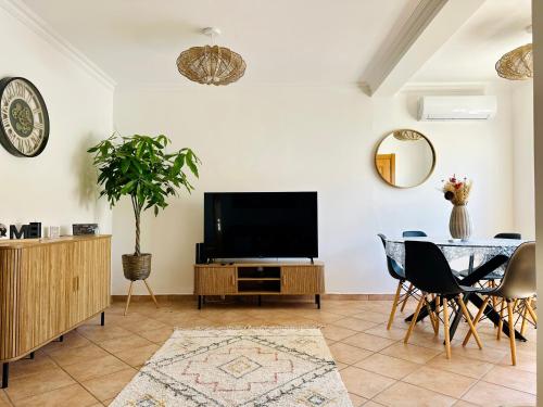 a living room with a television and a table at Casa Esperança in Albufeira