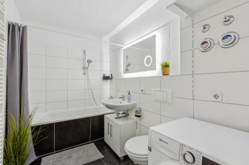 a white bathroom with a sink and a toilet at Aura - Nulandt#3 - 2 Zimmer, 4 Betten, Küche, Balkon, Waschmaschine in Merseburg